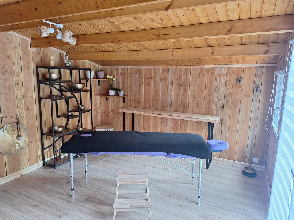 Vue d'ensemble de la salle de soin en bois clair avec la table de massage